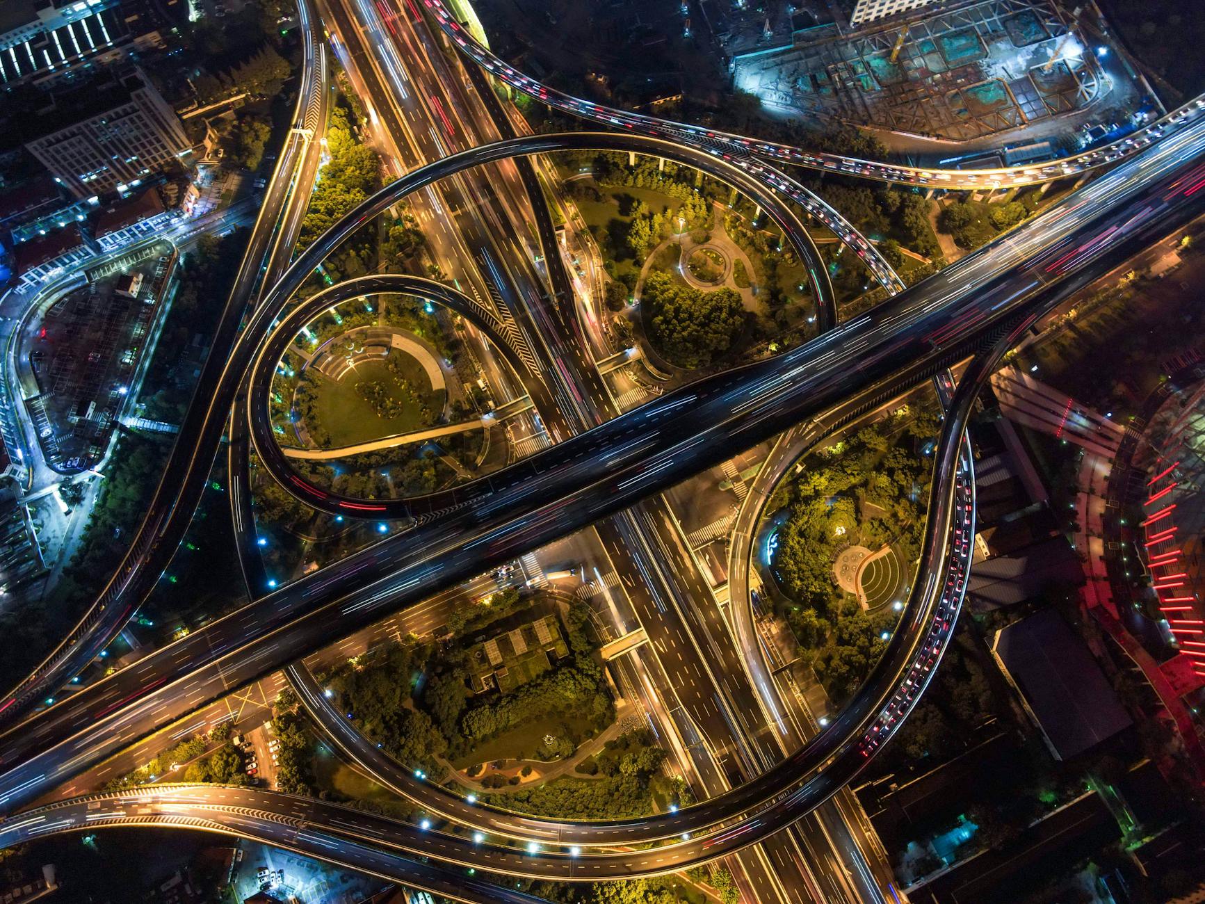 Nocne lotnicze ujęcie miejskich autostrad i skomplikowanych rond