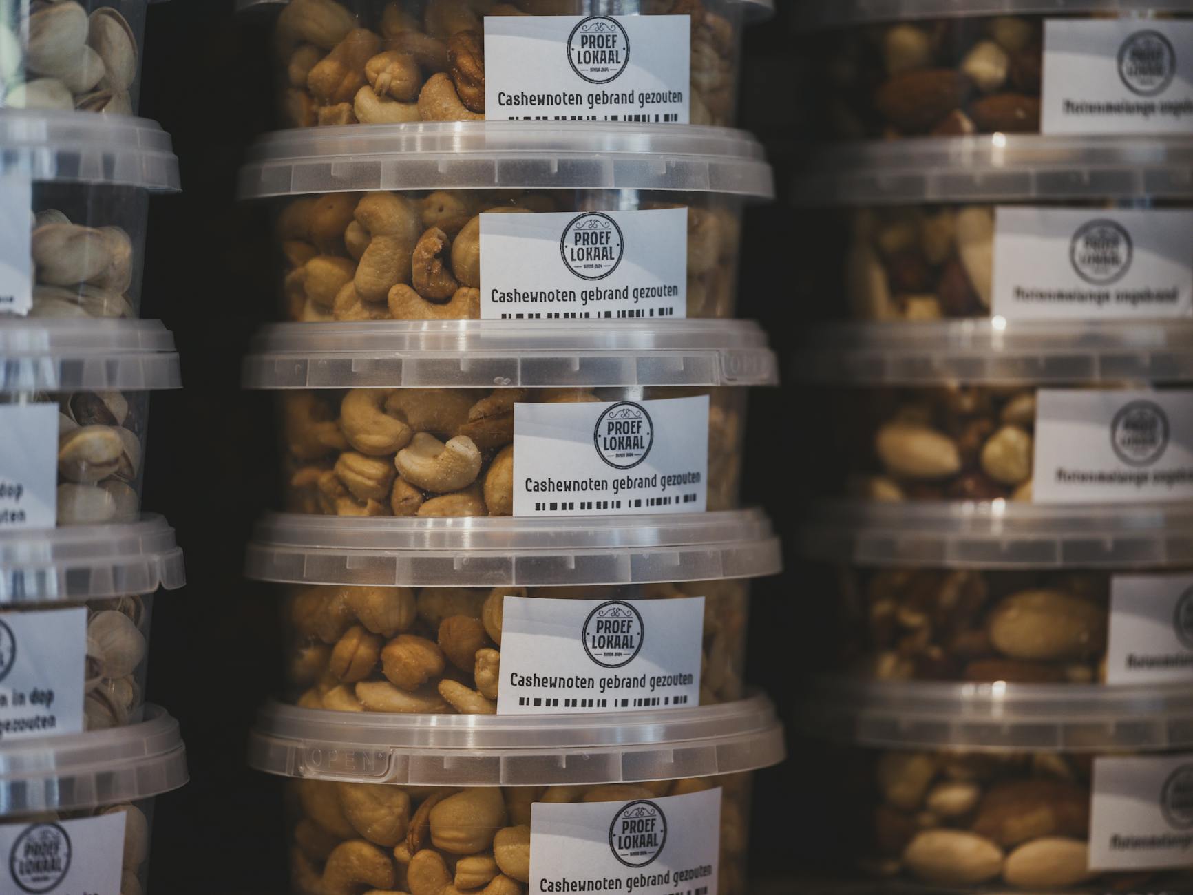 Pojemniki z prażonymi orzechami nerkowca ustawione na sklepowej półce