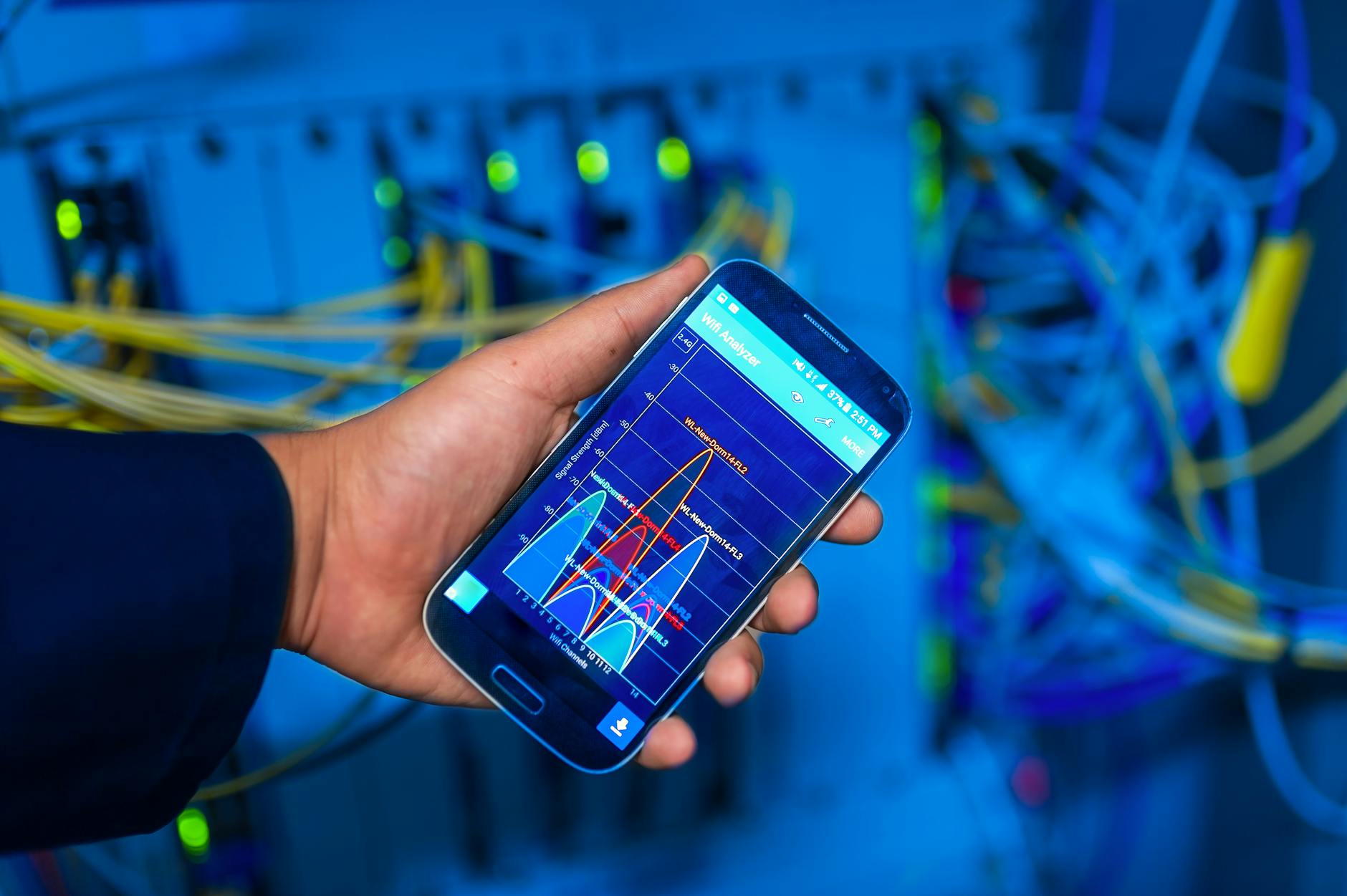 Smartfon z analizą sieci IoT na tle serwerowni