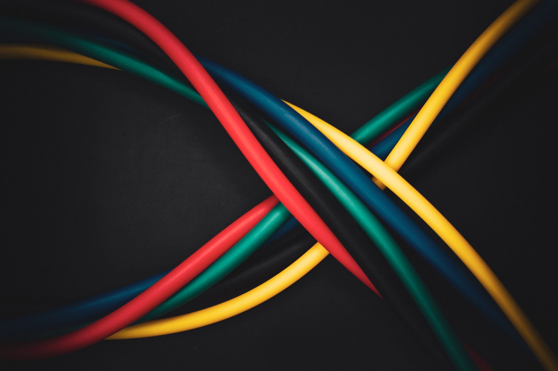 Splątane, wielokolorowe kable symbolizujące złożone połączenia technologii