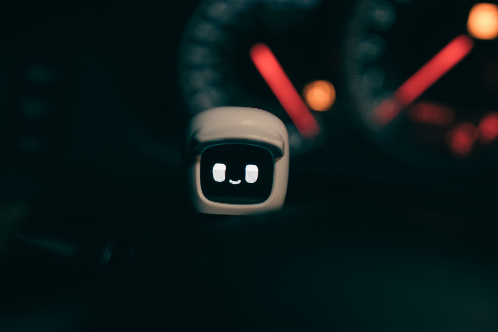 Od raportów w Excelu do autonomicznych rekomendacji AI w produkcji seryjnej Uśmiechnięty mały robot na desce rozdzielczej auta nocą